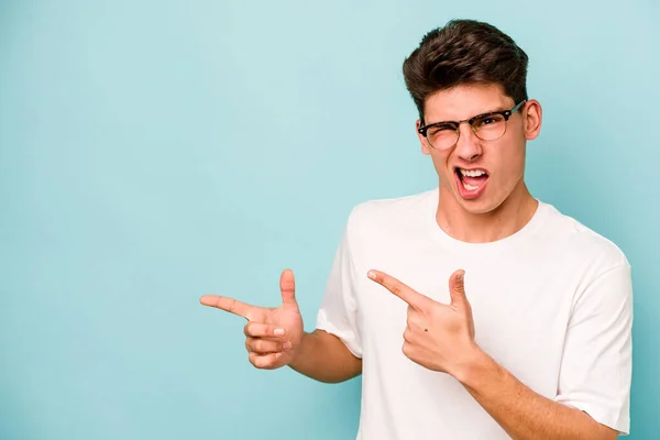 Young Caucasian Man Isolated Blue Background Pointing Forefingers Copy Space — Stock Photo, Image