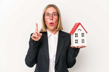 Beyaz arka planda izole edilmiş bir oyuncak evi tutan beyaz bir kadın. Harika bir fikir, yaratıcılık kavramı var..