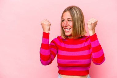 Pembe arka planda izole edilmiş beyaz bir kadın zaferden sonra yumruğunu kaldırıyor, kazanan konsept.