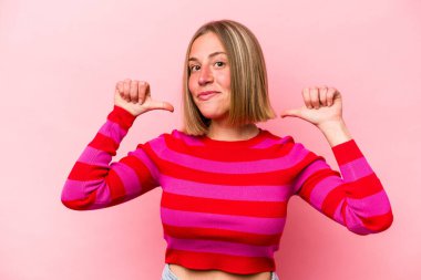 Pembe arka planda izole genç beyaz kadın gururlu ve kendinden emin hissediyor, örnek olarak..