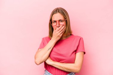 Pembe arka planda izole edilmiş genç beyaz kadın korkmuş ve korkmuş..