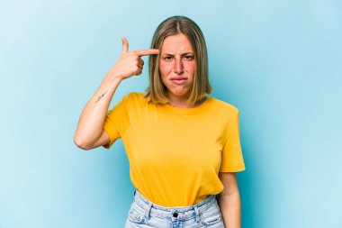 Mavi arka planda izole edilmiş beyaz bir kadın işaret parmağıyla hayal kırıklığı jesti yapıyor..