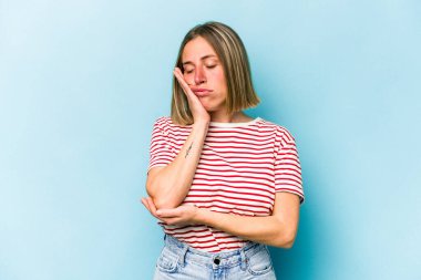 Mavi arka planda soyutlanmış, sıkılmış, yorgun ve dinlenmeye ihtiyacı olan beyaz bir kadın..