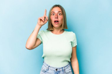 Mavi arka planda izole edilmiş beyaz bir kadın ağzı açık bir şekilde üst tarafı işaret ediyor..