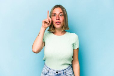 Kafkasyalı genç bir kadın mavi arka planda izole edilmiş. Harika bir fikri var, yaratıcılık kavramı..