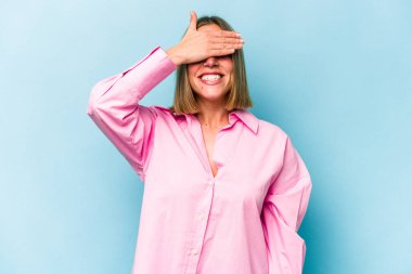 Mavi arka planda soyutlanmış beyaz bir kadın elleriyle gözlerini kapatıyor, gülümseyerek bir sürpriz bekliyor..