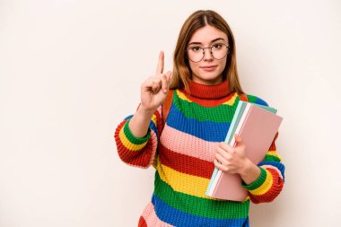 Young student caucasian woman isolated on white background showing number one with finger.