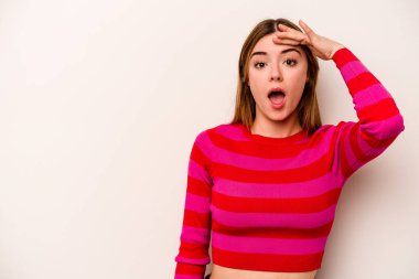 Beyaz arka planda izole genç beyaz kadın yüksek sesle bağırıyor, gözleri açık ve elleri gergin tutuyor..