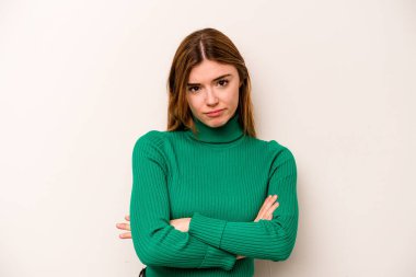 Beyaz arka planda izole edilmiş genç beyaz kadın şüpheli, belirsiz, seni muayene ediyor..