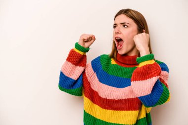 Beyaz arka planda izole genç beyaz kadın zafer kazandıktan sonra yumruğunu kaldırıyor, kazanan konsept..