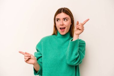 Beyaz arka planda izole edilmiş genç beyaz kadın farklı kopya alanlarını gösteriyor, birini seçiyor, parmaklarıyla gösteriyor.