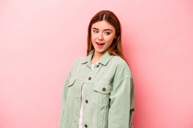 Pembe arka planda soyutlanmış beyaz bir kadın. Gülümsüyor, neşeli ve keyifli görünüyor..