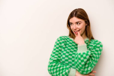 Beyaz arka planda izole edilmiş genç beyaz kadın rahatlamış bir şeyin fotokopi odasına baktığını düşünüyor..