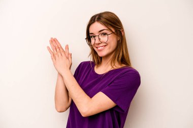 Beyaz arka planda izole edilmiş genç beyaz kadın enerjik ve rahat hissediyor, ellerini ovuşturuyor..