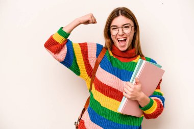 Young student caucasian woman isolated on white background raising fist after a victory, winner concept.