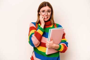 Young student caucasian woman isolated on white background biting fingernails, nervous and very anxious.