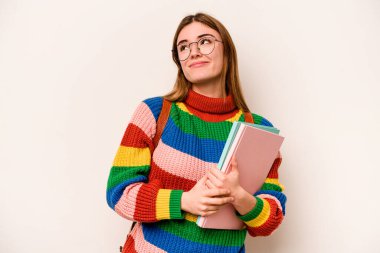 Young student caucasian woman isolated on white background dreaming of achieving goals and purposes