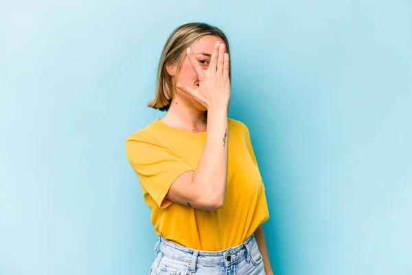 Jonge Blanke Vrouw Geïsoleerd Blauwe Achtergrond Knipperen Camera Door Vingers — Stockfoto