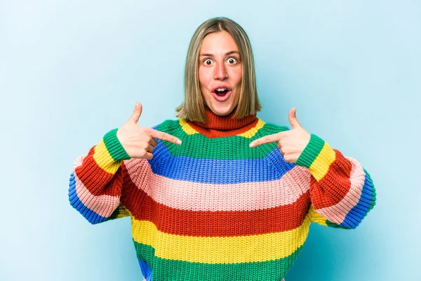 Mavi arka planda izole edilmiş genç beyaz kadın parmakları aşağıda, olumlu bir his var..