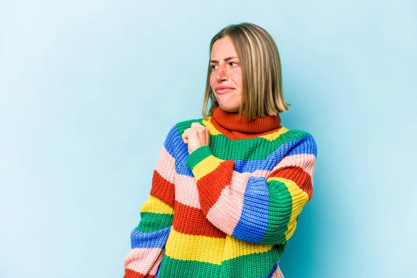 Kafkasyalı genç bir kadın mavi arka planda izole edilmiş, kafası karışmış, şüpheli ve kendinden emin değil..