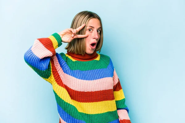 Genç beyaz kadın mavi arka planda izole edilmiş dans ediyor ve eğleniyor..