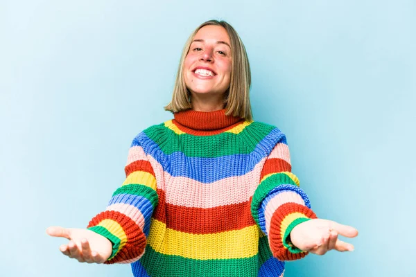 Mavi arka planda izole edilmiş beyaz bir kadın hoş bir ifade sergiliyor..