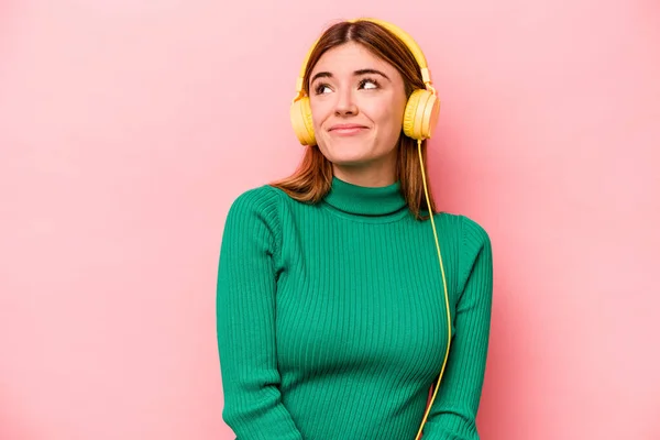 Young Caucasian Woman Listening Music Isolated Pink Background Dreaming Achieving — Φωτογραφία Αρχείου