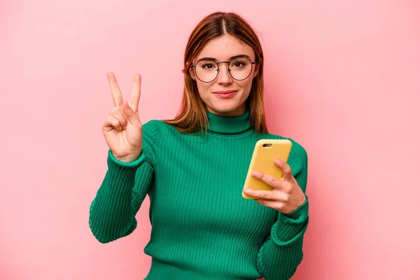 Молодая Белая Женщина Держит Мобильный Телефон Изолирован Розовом Фоне Показывает — стоковое фото