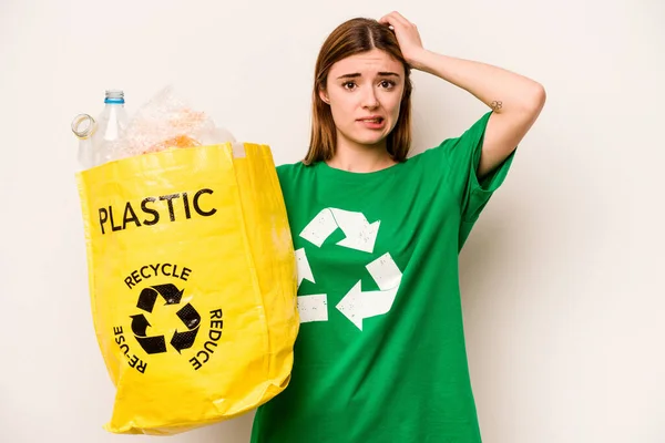 白い背景に隔離されたリサイクルのためのペットボトルの袋を持っている若い女性はショックを受けて 彼女は重要な会議を覚えています — ストック写真