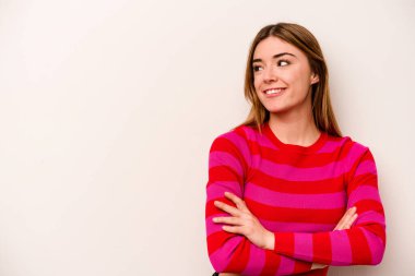 Beyaz arka planda soyutlanmış beyaz bir kadın kollarını kavuşturup gülümsüyor..