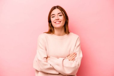 Genç beyaz kadın pembe arka planda izole edilmiş gülüyor ve eğleniyor..