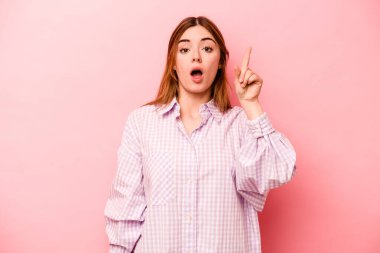 Pembe arka planda izole edilmiş beyaz bir kadın ağzı açık bir şekilde üst tarafı işaret ediyor..