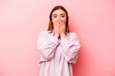 Pembe arka planda izole edilmiş beyaz bir kadın elleriyle ağzını kapatırken şok oldu..