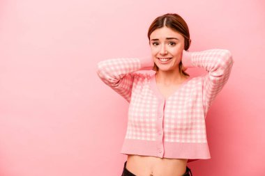 Kafkasyalı genç bir kadın pembe arka planda izole edilmiş kafasının arkasına dokunuyor, düşünüyor ve bir seçim yapıyor..