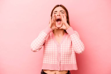 Pembe arka planda izole edilmiş beyaz bir kadın heyecanlı bir şekilde bağırıyor..