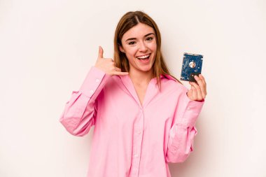 Beyaz arka planda izole edilmiş genç, gayri resmi beyaz kadın parmaklarıyla bir cep telefonu çağrısı hareketi gösteriyor..