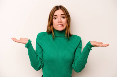 Beyaz arka planda izole edilmiş genç beyaz bir kadın. Kafası karışmış ve omuz silkiyor. Kopya alanını tutmak için..