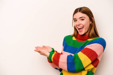 Beyaz arka planda izole edilmiş beyaz tenli genç bir kadın palmiyesinde bir kopya alanı tutuyor..