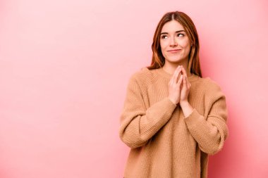 Kafkasyalı genç bir kadın pembe arka planda izole edilmiş bir plan yapıyor, bir fikir kuruyor..