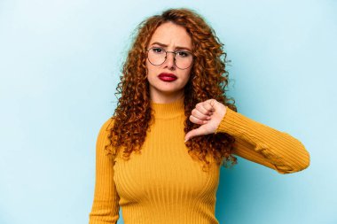 Mavi arka planda izole edilmiş genç, beyaz bir kadın hoşlanmadığı bir hareket gösteriyor. Anlaşmazlık konsepti.