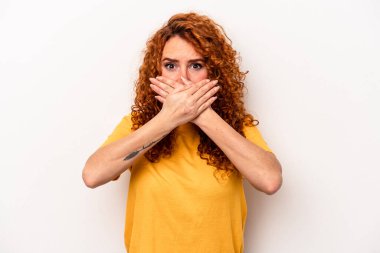 Beyaz arka planda izole edilmiş, elleri endişeli bir şekilde ağzı kapalı, genç, beyaz bir beyaz kadın..