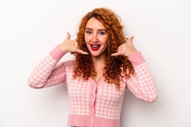 Beyaz arka planda izole edilmiş genç, beyaz tenli kadın parmaklarıyla bir cep telefonu çağrısı hareketi gösteriyor..