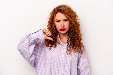 Beyaz arka planda izole edilmiş genç, beyaz bir kadın baş parmağını aşağı gösteriyor ve hoşlanmadığını ifade ediyor..