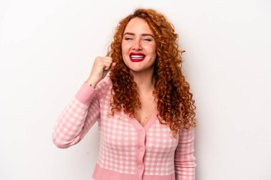 Beyaz arka planda izole edilmiş beyaz tenli genç bir kadın zafer, tutku ve coşkuyu kutluyor, mutlu bir ifade..