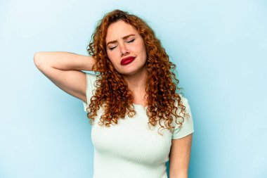 Genç beyaz kadın, mavi arka planda izole edilmiş dirsek masajı yapıyor, kötü bir hareketin ardından acı çekiyor..