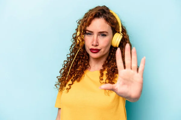 Young Ginger Woman Listening Music Isolated Blue Background Standing Outstretched — Stock Photo, Image