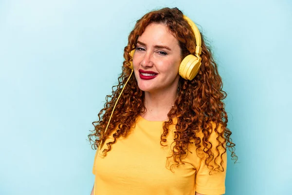 Joven Pelirroja Escuchando Música Aislada Sobre Fondo Azul Feliz Sonriente —  Fotos de Stock