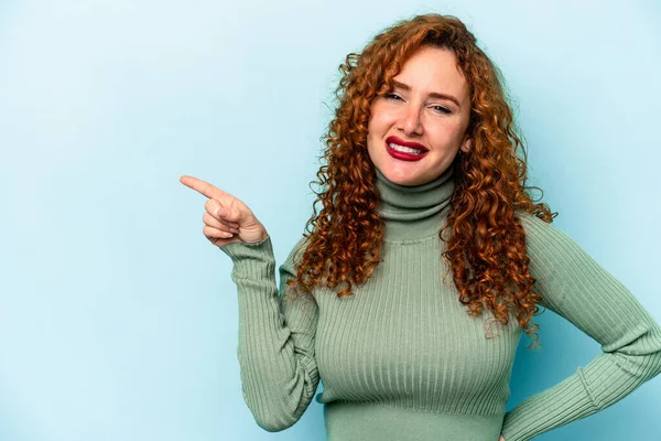 Joven Pelirroja Caucásica Aislada Sobre Fondo Azul Sonriendo Alegremente Señalando —  Fotos de Stock