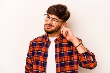 Beyaz arka planda izole edilmiş, kulakları parmaklarla kaplayan, stresli ve çaresiz genç bir İspanyol..