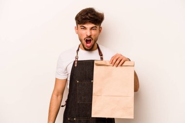 Beyaz arka planda izole edilmiş, öfkeli ve agresif bir şekilde bağıran bir çanta taşıyan genç İspanyol tezgahtar..